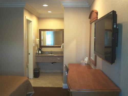 a hotel room with a bathroom with a sink and a television at Hyland Motel Van Nuys in Van Nuys