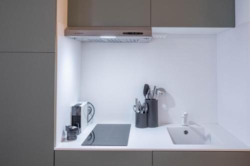 une cuisine blanche avec un évier et un micro-ondes dans l'établissement Diamond Apartment, à Cannes