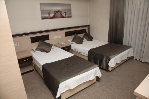 a hotel room with two beds in a room at Vita Park Boutique Hotel in Konak