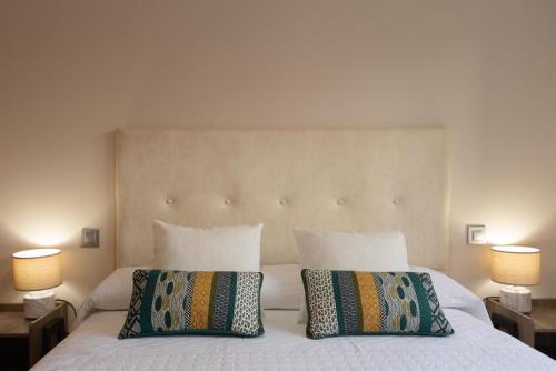 ein Schlafzimmer mit einem Bett mit zwei Kissen und zwei Lampen in der Unterkunft Apartamento Bulevar 1 con parking gratuito in Castellón de la Plana