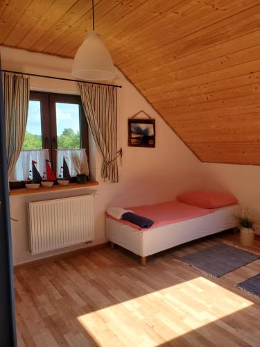 ein Schlafzimmer mit einem Bett im Dachgeschoss in der Unterkunft Zagroda Berezanka 600-739-125 in Polańczyk