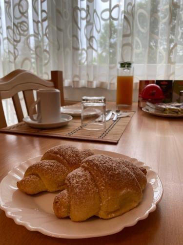 zwei Croissants auf einem Teller auf dem Tisch in der Unterkunft House Kajfes in Plitvička Jezera