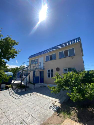 a building with the sun in the sky at Eldos-Ata Eco Hotel in Tossor