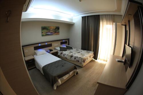 Habitación de hotel con 2 camas y ventana en Vita Park Boutique Hotel, en Konak