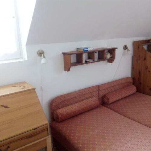 une chambre avec un canapé et une étagère sur le mur dans l'établissement Szentmihályi apartman, à Balatonboglár