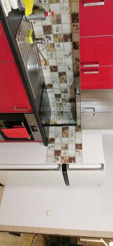 a kitchen counter with red cabinets and a drawer at Apartman in Velyka Bihan Берегівський район - Закарпаття in Velyka Bihanʼ
