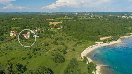 an aerial view of a house on a hill next to the ocean at Holiday Home Saladinka with Whirlpool in Poreč