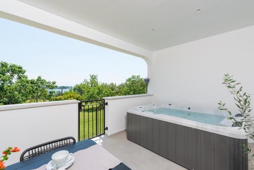 a hot tub on the balcony of a house at Holiday Home Saladinka with Whirlpool in Poreč