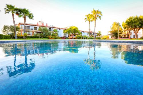 ein großer Pool mit blauem Wasser und Palmen in der Unterkunft Pura Villa- Buganvillas Ayamonte in Ayamonte