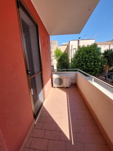 an empty balcony with an open door and a window at La Maddalenetta Casa Vacanze in Alghero
