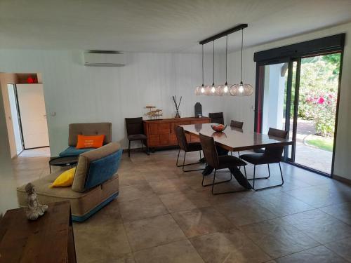 un salon avec une table et une salle à manger dans l'établissement Villa élégante, jardin bucolique, proche golf & plages, 4 étoiles - FR-1-239-698, à Capbreton