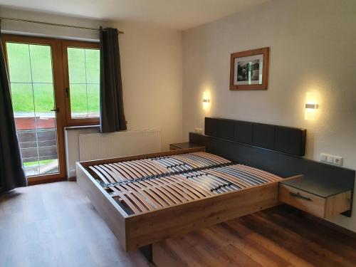 a bedroom with a large wooden bed in front of a window at Zasserlhof Familie Bamberger in Kössen