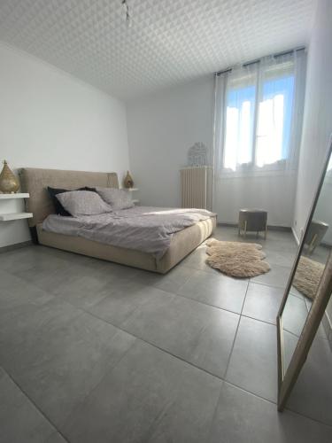 - une chambre blanche avec un lit et une fenêtre dans l'établissement Location T3 entier à 5 minutes de l’aéroport, à Marignane