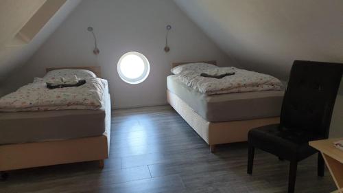 a attic room with two beds and a window at Ferienwohnung Bensdorf in Bensdorf