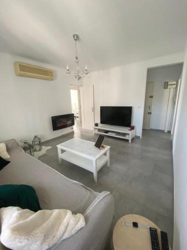 a living room with a couch and a tv at Location T3 entier à 5 minutes de l’aéroport in Marignane