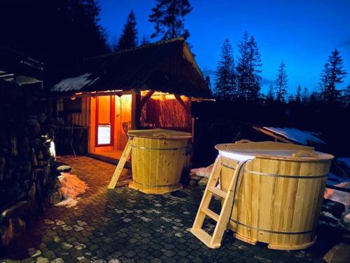 a cabin with two large barrels in front of it at Domki i Apartamenty Na Wyskówkach Jacuzzi & Sauna in Zakopane