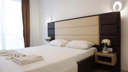 a bedroom with a bed with a black and white headboard at Ponte Apartments in Ulcinj