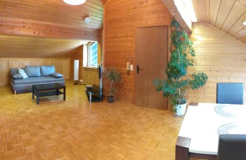a living room with a blue couch in a room at 2-Zimmer DG-Apartment mit eigener Sauna in Oberhaching