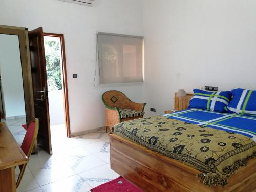a bedroom with a bed and a table and chairs at Marys Guest House in Lomé