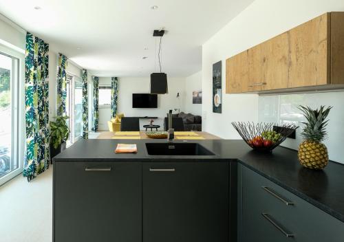 a kitchen with a black counter top and a living room at Domizil Relax - Seeluft in Überlingen