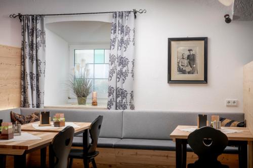 a living room with a couch and tables and a window at Farbinger Hof in Bernau am Chiemsee