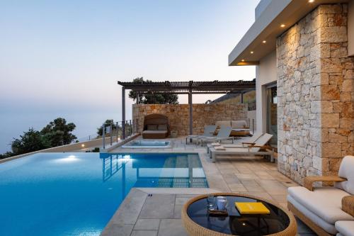 een zwembad met een patio en een villa bij Melampes Villa in Mélambes
