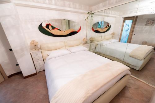 1 dormitorio con 2 camas y 2 espejos en B&B Le Dodici Marie, en Alatri