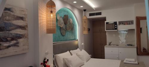 ミクロス・ギアロスにあるIlianthos Apartments & Roomsのリビングルーム(ベッド1台付)、キッチンが備わります。