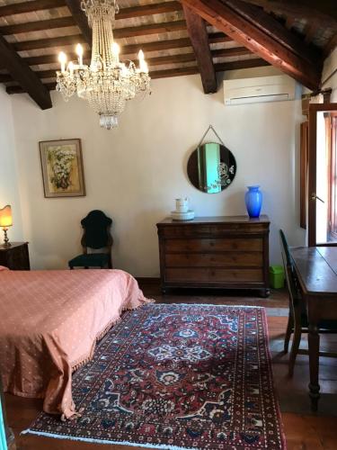 - une chambre avec un lit, une table et un lustre dans l'établissement Camera in Riviera a metà fra Venezia e Padova, à Mira