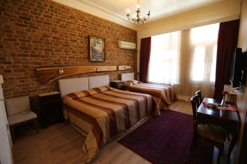 a bedroom with two beds and a brick wall at Yeşilköy Airport Hotel in Istanbul