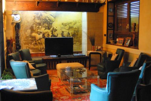 un salon avec des chaises et une télévision dans l'établissement Hostal Victor, à Oliana