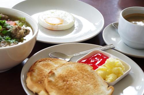 een tafel met borden ontbijtproducten en een kopje koffie bij ฺBokkhorani resort in Ban Mai