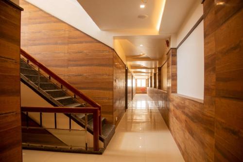 a hallway with wooden walls and stairs in a building at sri balaji grand hotel in Kumbakonam