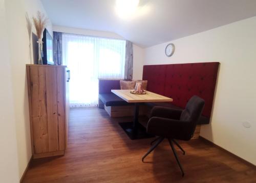 a dining room with a table and a chair at Hotel Garni Wolfgang in Saalbach Hinterglemm