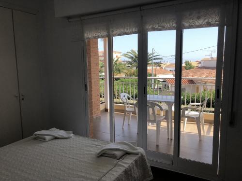 a bedroom with a bed and a view of a balcony at Mediterraneo Playa-Serviden in Denia