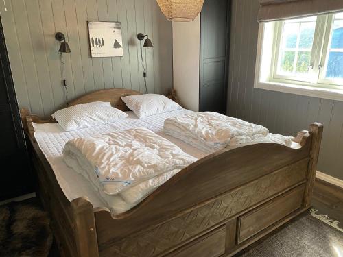 an unmade bed in a bedroom with a window at Lifjelltunet in Lifjell