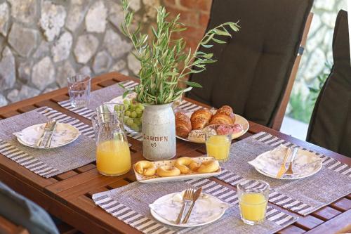 une table en bois avec des assiettes de nourriture et de jus d'orange dans l'établissement Country House Frane, à Lađevci