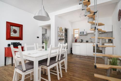 una cucina e una sala da pranzo con tavolo e sedie bianchi di Country House Frane near Krka Waterfalls & Šibenik a Lađevci