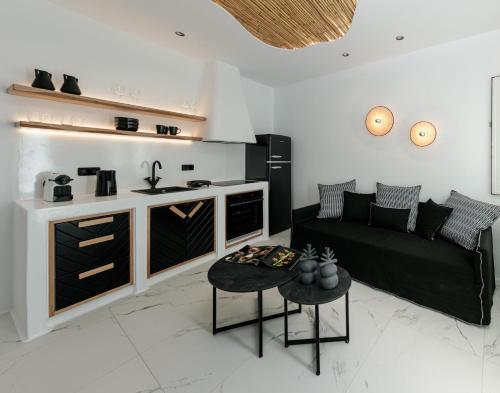 sala de estar con sofá negro y cocina en Black Concept Maisonette, en Naxos Chora