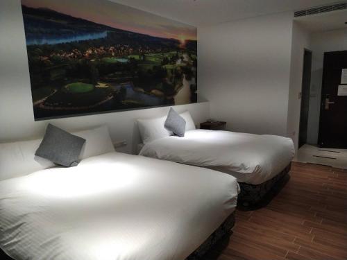 two beds in a hotel room with a painting on the wall at π 園周綠溫泉會館-泉鄉雅舍 in Jiaoxi