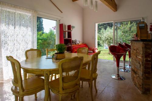 Les Manaux en Provence في Roquevaire: غرفة طعام مع طاولة وكراسي خشبية