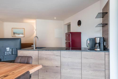 a kitchen with a counter and a red refrigerator at Aumia Apartment Rubin in Fiè