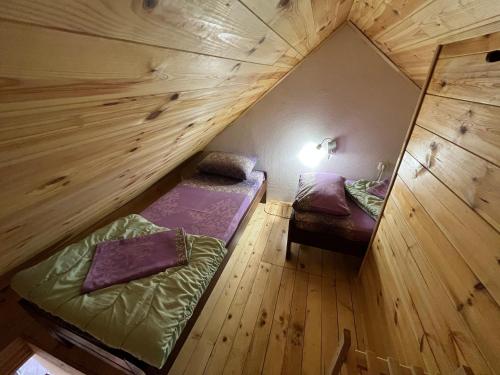 um quarto no sótão com 2 camas e um espelho em Dormire Apartmans em Žabljak