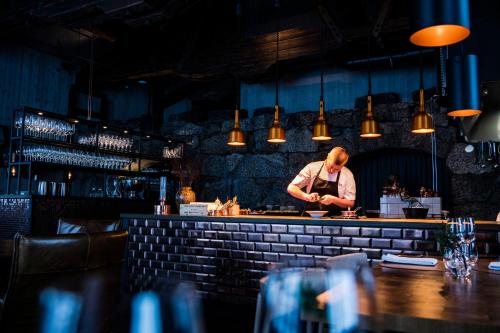 a man standing behind a bar preparing food at Niehku Mountain Villa in Riksgränsen