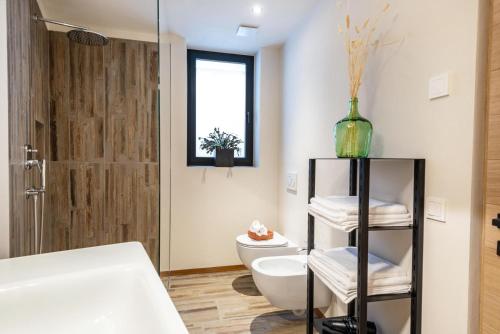 y baño con bañera, aseo y lavamanos. en Aumia Apartment Opal, en Fiè