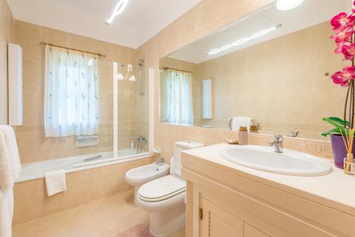 a bathroom with a sink and a toilet and a mirror at Boavista Charming Apartment in Lagos