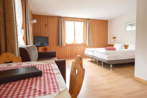 HeiligkreuzにあるHotel Kurhaus Heiligkreuzのベッド2台とソファが備わるホテルルームです。