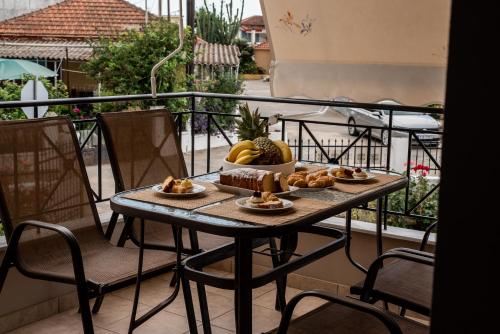 una mesa con comida en la parte superior de un balcón en Agathi's house, en Mitikas