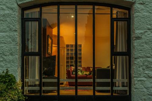 a window of a living room with a person sitting on a couch at No.1 The Coach House in Silverdale