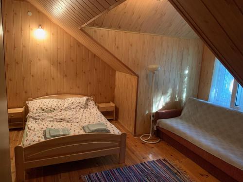 a bedroom with a bed and a couch in a attic at Siedlisko Nasza Chata in Popiołki